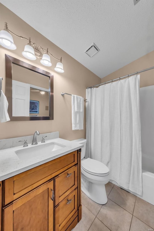 bathroom with a textured ceiling, tile patterned flooring, toilet, vanity, and visible vents