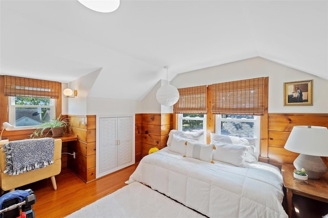 bedroom with a closet, hardwood / wood-style floors, and lofted ceiling