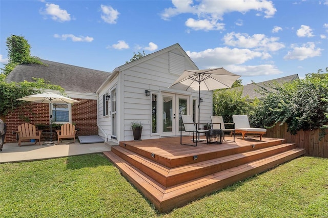 back of property with a deck, a yard, and french doors