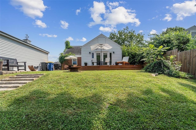 back of house featuring a deck and a lawn