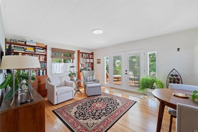 living area with french doors and light wood-type flooring