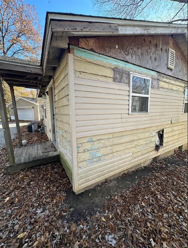 view of side of property with a garage, an outdoor structure, and central air condition unit