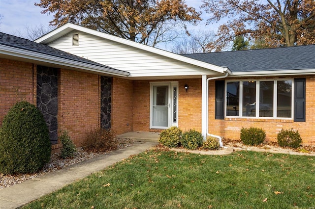 doorway to property with a lawn