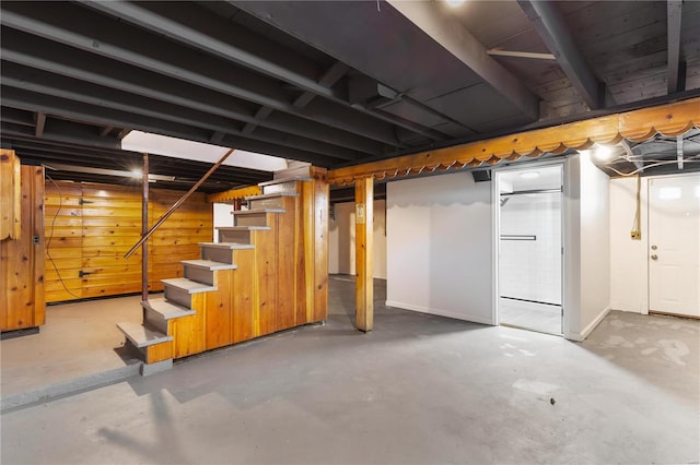 basement featuring wooden walls