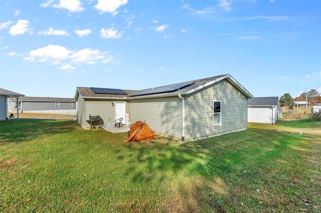 view of side of property with a lawn and solar panels