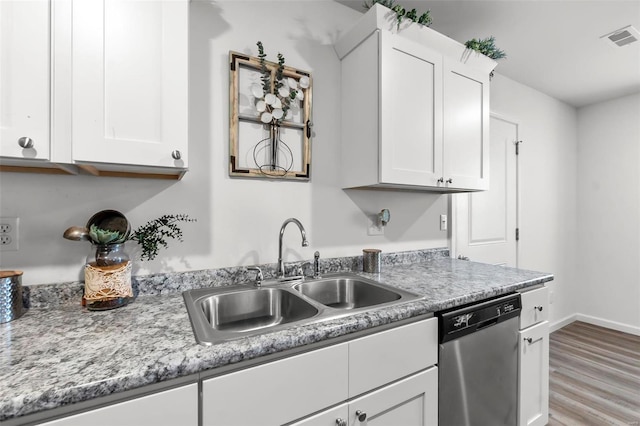 kitchen with dishwasher, sink, light stone counters, light hardwood / wood-style flooring, and white cabinets