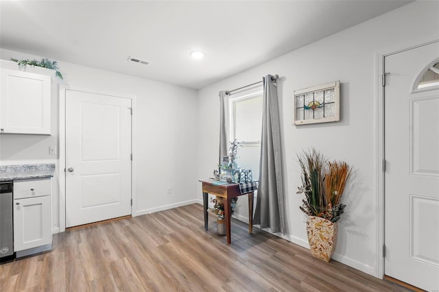 interior space with dishwasher, light wood-type flooring, and white cabinetry