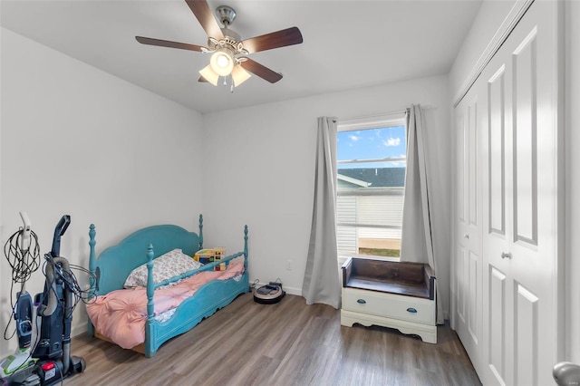 bedroom with a closet, hardwood / wood-style flooring, and ceiling fan