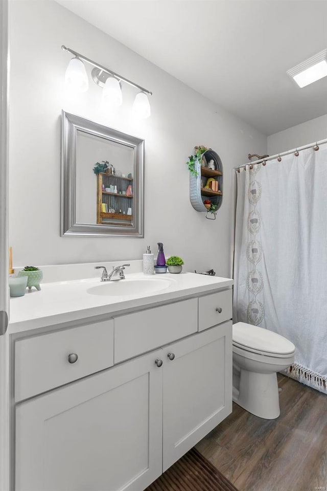 bathroom featuring vanity, hardwood / wood-style flooring, and toilet