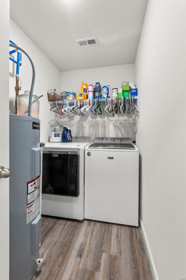 laundry area featuring hardwood / wood-style floors, washer and clothes dryer, and electric water heater