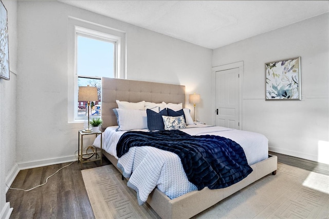 bedroom with wood finished floors and baseboards