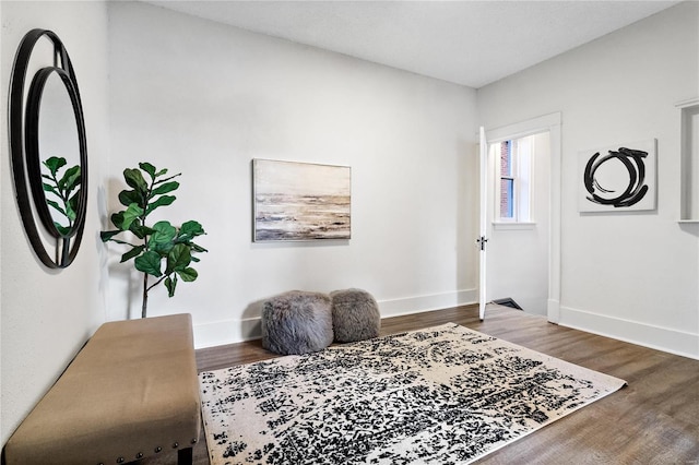 living area with baseboards and wood finished floors