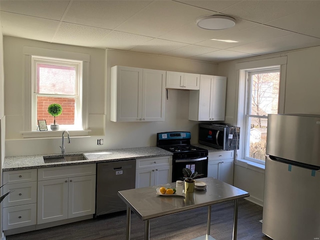 kitchen featuring stainless steel appliances, a wealth of natural light, white cabinetry, and a sink