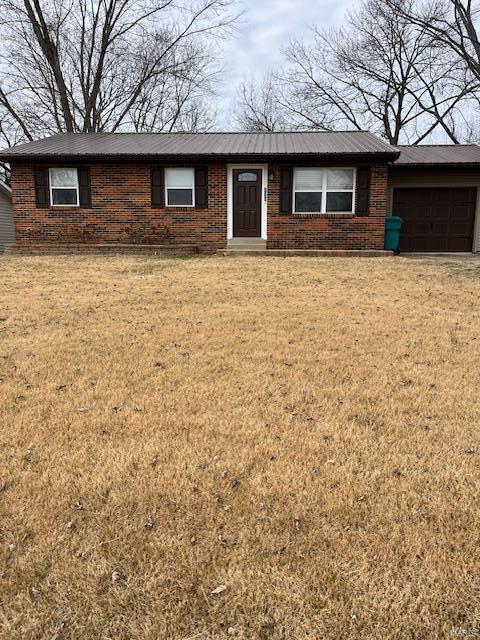 single story home with a garage and a front lawn