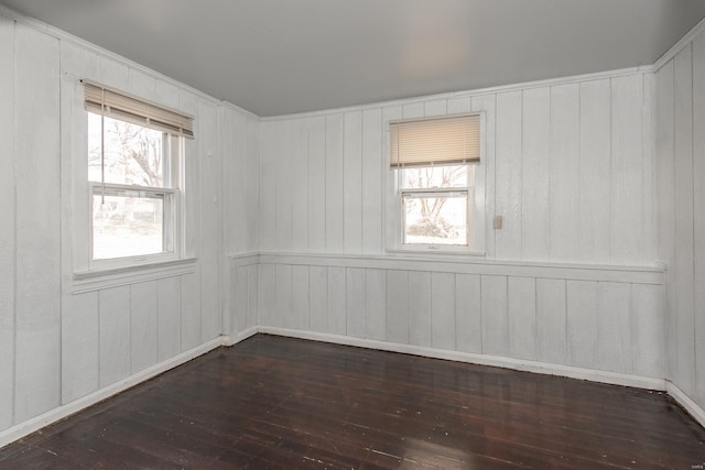 unfurnished room with dark hardwood / wood-style flooring and wooden walls