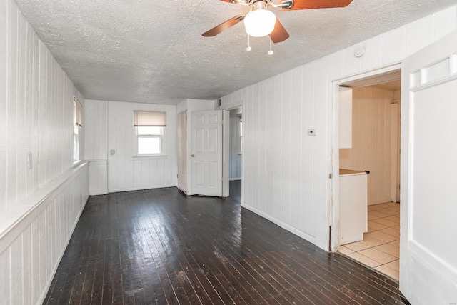 unfurnished room featuring a ceiling fan, wood-type flooring, and a textured ceiling