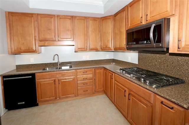 kitchen with decorative backsplash, dark stone counters, stainless steel appliances, sink, and light tile patterned floors