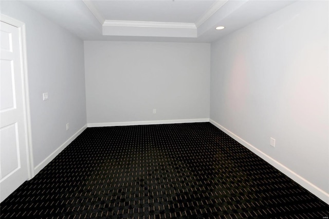 carpeted spare room with a raised ceiling and ornamental molding