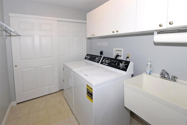 clothes washing area featuring cabinets, washer and dryer, and sink