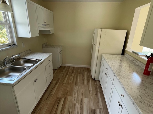 kitchen featuring white fridge, light hardwood / wood-style floors, white cabinetry, and sink