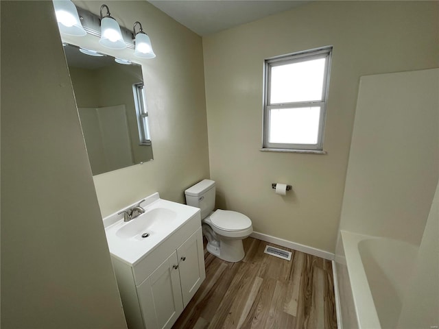 bathroom with hardwood / wood-style floors, vanity, and toilet