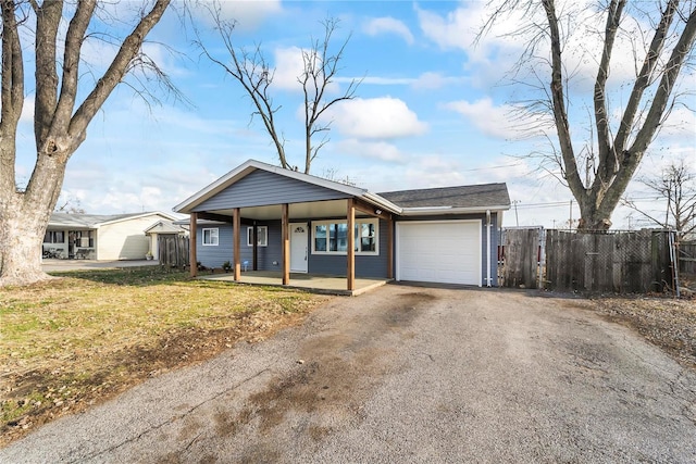 ranch-style house featuring a garage, covered porch, and a front yard