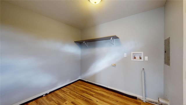 laundry area featuring hookup for a washing machine, electric panel, and light hardwood / wood-style floors