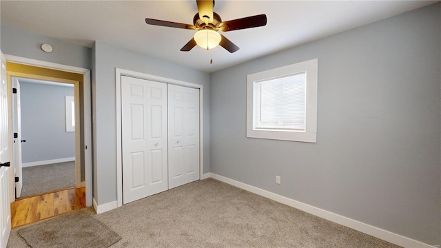 unfurnished bedroom featuring light colored carpet, ceiling fan, and a closet