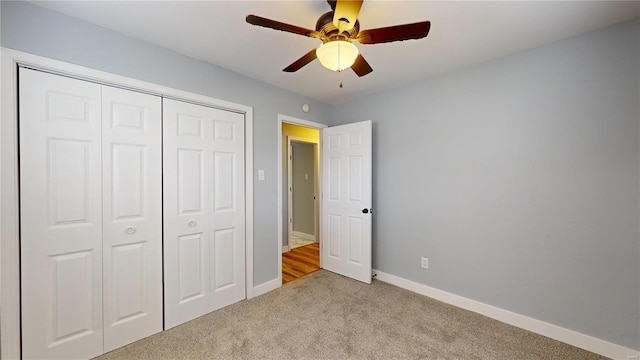 unfurnished bedroom featuring light carpet, ceiling fan, and a closet