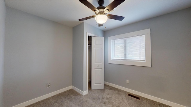 unfurnished bedroom featuring light carpet, a closet, and ceiling fan