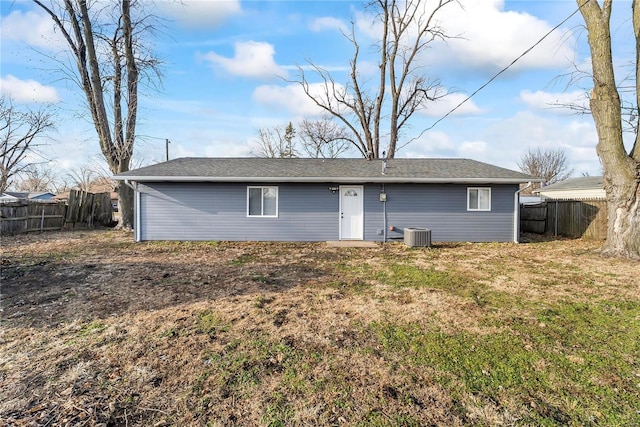 rear view of property featuring central AC and a yard