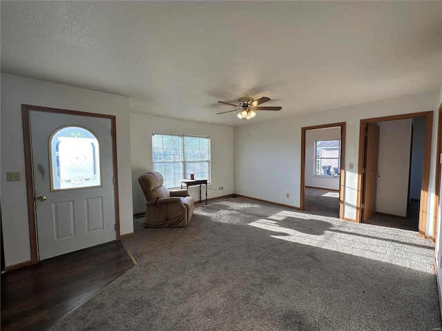 foyer entrance featuring dark hardwood / wood-style floors, ceiling fan, a healthy amount of sunlight, and a textured ceiling