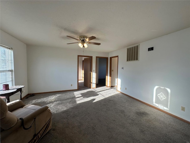 unfurnished living room with ceiling fan, carpet floors, and a textured ceiling