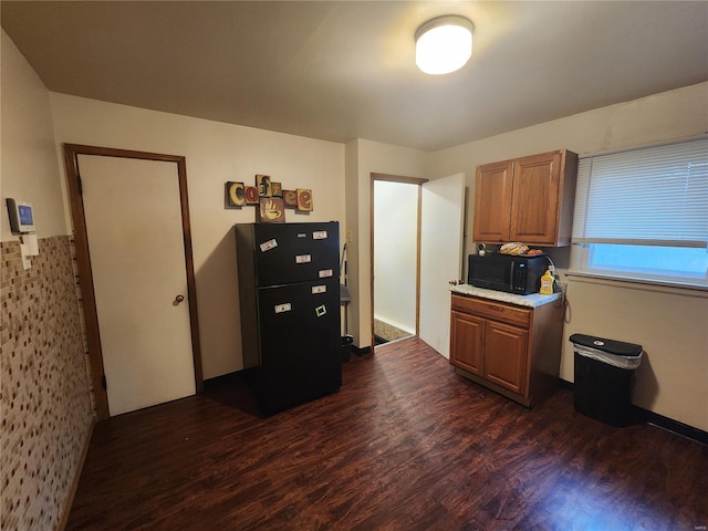 kitchen featuring dark hardwood / wood-style flooring and black appliances