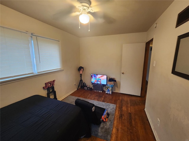 bedroom with dark wood finished floors, baseboards, and ceiling fan