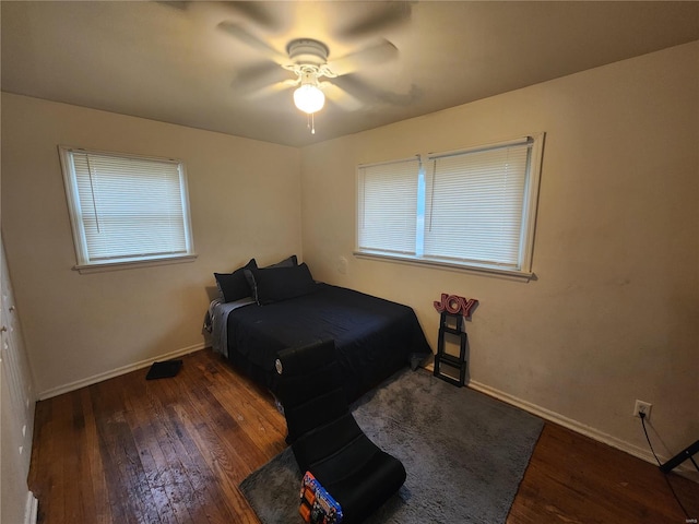 bedroom with dark wood-style flooring, multiple windows, ceiling fan, and baseboards