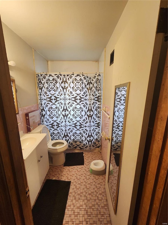 bathroom with a shower with curtain, tile walls, vanity, and toilet