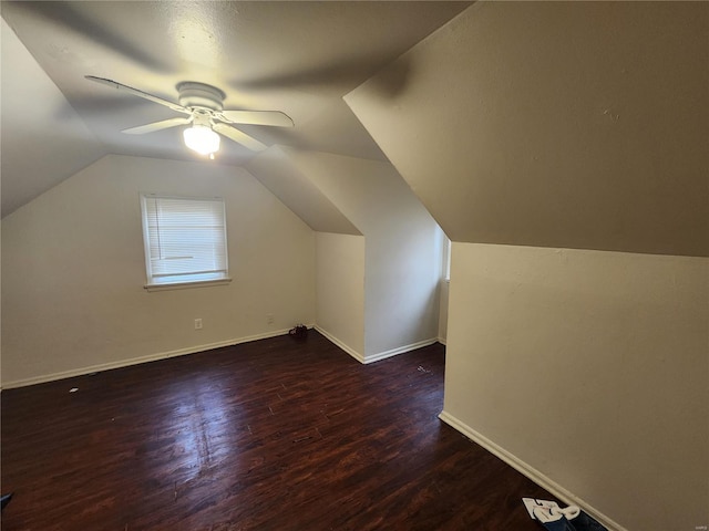 additional living space featuring vaulted ceiling, dark wood finished floors, baseboards, and ceiling fan