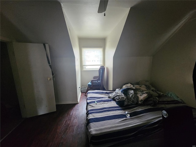 bedroom with a ceiling fan, vaulted ceiling, and dark wood-type flooring