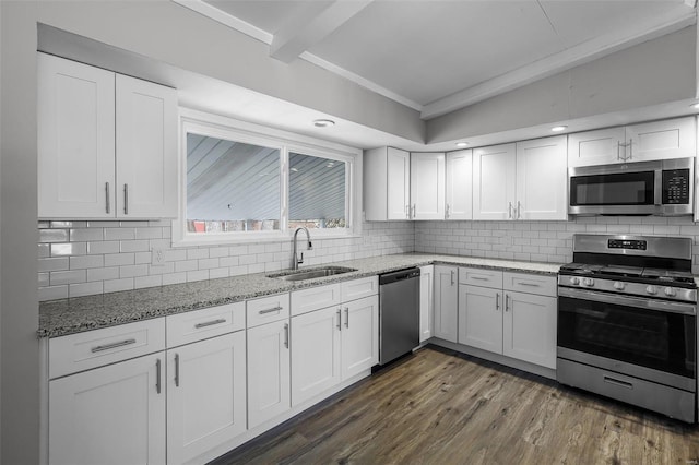 kitchen with decorative backsplash, stainless steel appliances, white cabinetry, and sink