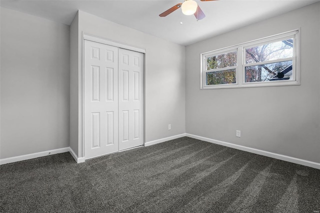 unfurnished bedroom featuring ceiling fan, a closet, and dark colored carpet