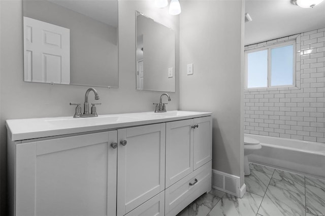 full bathroom featuring tiled shower / bath, vanity, and toilet