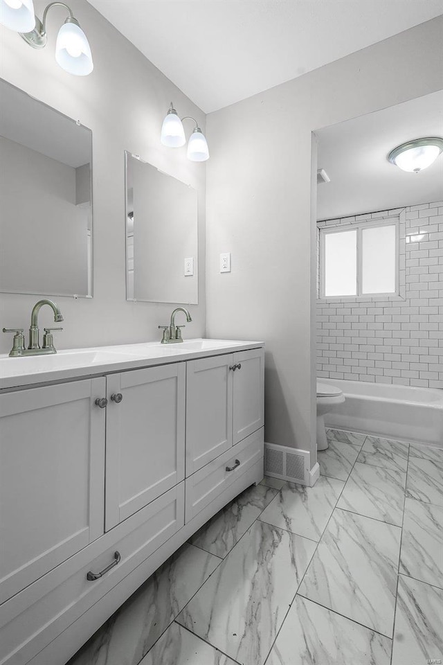 full bathroom featuring vanity, toilet, and tiled shower / bath combo