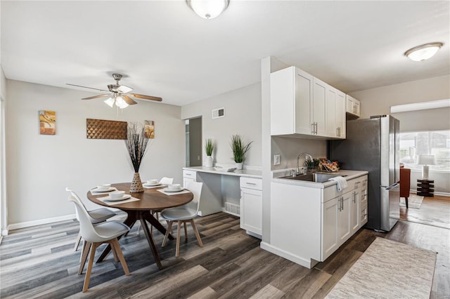 kitchen with white cabinetry, sink, ceiling fan, dark wood-type flooring, and kitchen peninsula