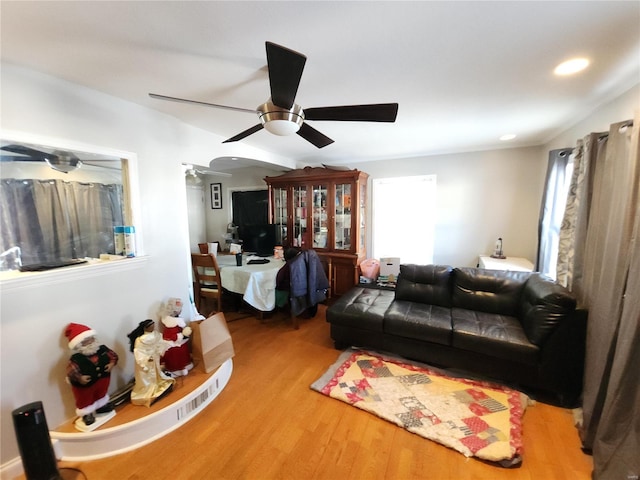 living area with arched walkways, ceiling fan, wood finished floors, and recessed lighting