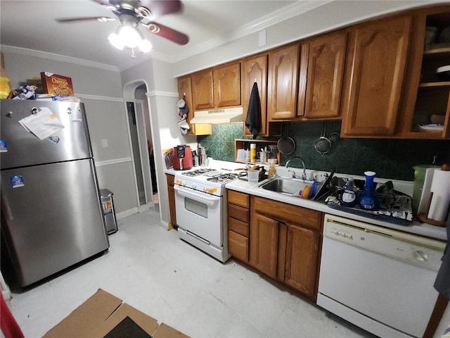 kitchen featuring white appliances, brown cabinets, light countertops, crown molding, and under cabinet range hood