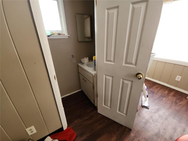 bathroom with wood finished floors, vanity, and baseboards