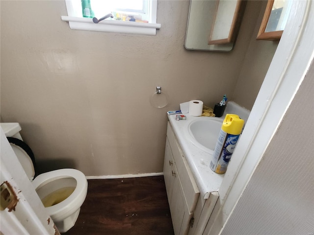 bathroom featuring toilet, wood finished floors, vanity, and baseboards