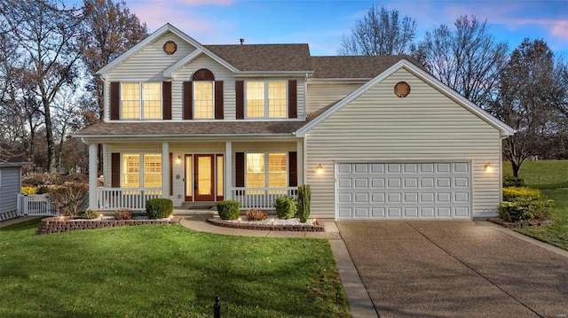 front facade featuring a yard, covered porch, and a garage