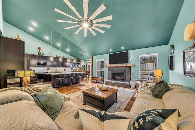 living room with vaulted ceiling, a notable chandelier, and light wood-type flooring